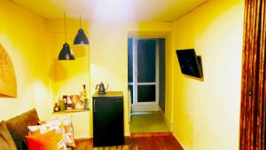 a yellow living room with a sink and a door at City Center Suit in Yerevan