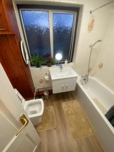 a bathroom with a sink and a toilet and a tub at 2 Bedroom Flat Available To Let in Abbey Wood