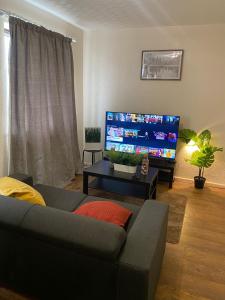 a living room with a couch and a flat screen tv at 2 Bedroom Flat Available To Let in Abbey Wood