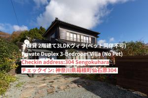 un panneau devant une maison avec un bâtiment dans l'établissement SPRINGS VILLAGE HAKONE Glamping Resort, à Hakone