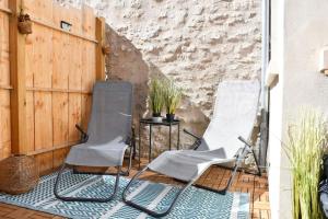 Duas cadeiras e uma mesa num pátio em La Casa De Nonna - logement classé 2 étoiles em Rochefort