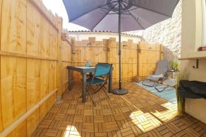 un patio con mesa y sombrilla en La Casa De Nonna - logement classé 2 étoiles en Rochefort