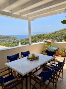 a table and chairs on a balcony with a view of the ocean at Elichrisos Apartment Spetses in Spetses
