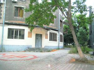 un edificio con un árbol delante de él en City Center Suit, en Ereván