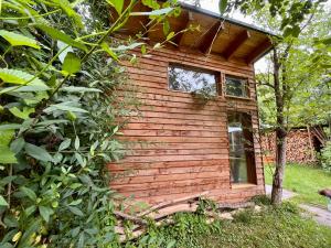 a small wooden cabin with a window in the grass at Häuschen in den Erlen in Eberswalde