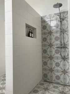 a bathroom with a shower with a tile wall at Bed & Breakfast By Genck in Oudenbosch