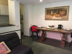 リヴォルノにあるB&B Villa Panicucciのリビングルーム(テーブル、赤い椅子付)