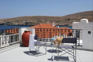 a balcony with two chairs and a vase on a building at Paraporti Room 2 in Andros +4 photos