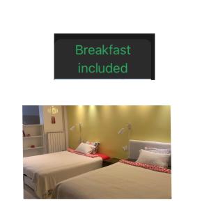 two beds in a room with a sign that reads breakfast included at Apartment A&D in Pančevo