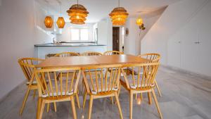 a kitchen with a wooden table and chairs at Jardines de la Duquesa 26 in Manilva