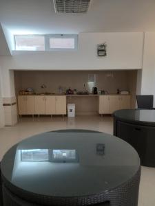 a room with a glass table and a kitchen at Apartments Philip II in Ohrid