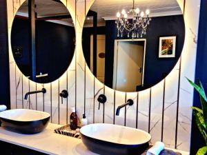 PJURE Wellness Retreat & Spa في مونتاغو: حمام به مغسلتين ومرآة كبيرة