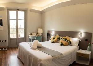 Un dormitorio con una gran cama blanca y una ventana en Locanda agli Amici, en Cortona