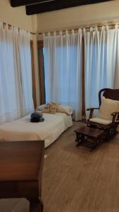 ein Schlafzimmer mit einem Bett, einem Sofa und einem Stuhl in der Unterkunft Villa Ca Na Llum in Trebeluger