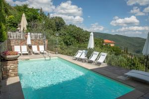 einen Pool mit Liegestühlen und Sonnenschirmen in der Unterkunft Locanda agli Amici in Cortona