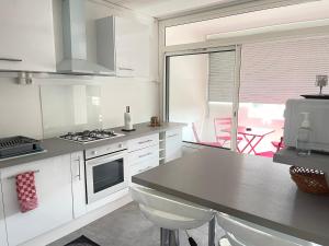 uma cozinha com armários brancos e uma bancada em Eurexpo Lyon à 9 min ,Groupama Stadium à 14 min em Saint-Priest