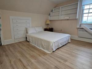 1 dormitorio con 1 cama, vestidor y ventana en Sunflower Guest Suites, en Summerside