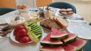 a table with a plate of fruit and bread on it at Hotel DownTown Avlabari in Tbilisi City