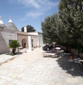 un patio con 2 mesas de picnic y un edificio en Trulli: La pace dei sensi, en Alberobello