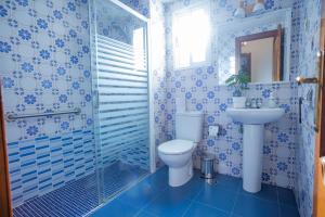 baño azul y blanco con aseo y lavamanos en Apartamento Parque Mediterráneo, en Málaga