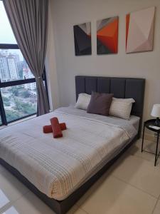 un lit avec un animal farci rouge au dessus dans l'établissement Arte Mont Kiara Pool View, à Kuala Lumpur