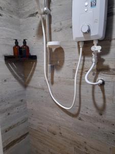 une douche avec un tuyau blanc fixé à un mur dans l'établissement Arte Mont Kiara Pool View, à Kuala Lumpur