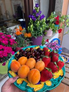 einen Obstteller auf einem Tisch mit Blumen in der Unterkunft Casa Castagna in Salerno