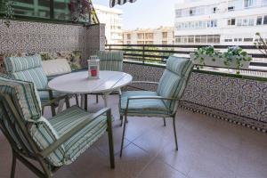 una mesa y sillas sentadas en un balcón en Apartamento Parque Mediterráneo, en Málaga