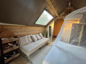 a room with a white couch and a window at Glamping Tuscany - Podere Cortesi in Santa Luce