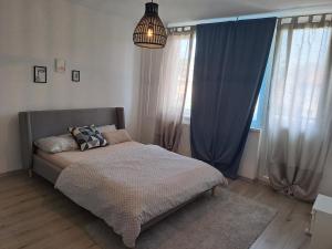 een bed in een slaapkamer met blauwe gordijnen en een lamp bij Enjoy traveling in Tuzla