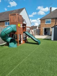 um parque infantil com um escorrega num quintal em Somers Lodge em Leicester
