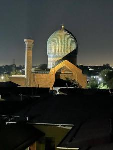 a large building with a dome and a tower at night at CRYSTAL GUEST HOUSE in Samarkand