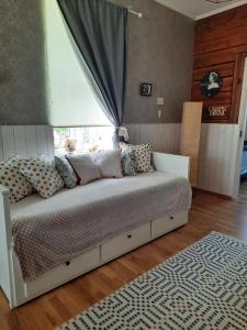 1 dormitorio con cama con almohadas y ventana en Vintage Four en Haapsalu