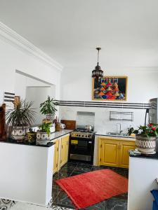 a kitchen with yellow cabinets and a stove at Chez abdelilah in Oualidia