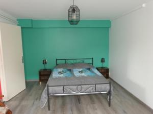 a bedroom with a bed and a blue wall at Logement spacieux rez-de-chaussée, jardin, stationnement devant, à 5 minutes à pied du centre de Sarlat in Sarlat-la-Canéda