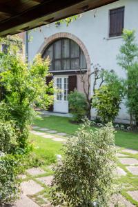 a house with a garden with bushes in front of it at B&B Arco Di Pietra in Quinto di Treviso