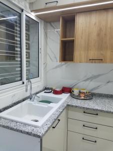 een keuken met een wastafel en een raam bij Joli Villa à Sahloul in Sousse