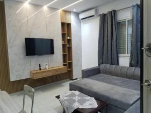 een woonkamer met een bank en een flatscreen-tv bij Joli Villa à Sahloul in Sousse