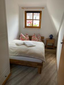 a small bedroom with a bed with a window at Ferienwohnung „Am Bankzeitweg“ in Saalfeld