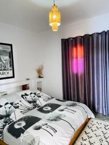 1 dormitorio con cama y cortina púrpura en Chez abdelilah, en Oualidia
