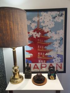a lamp on a table with a picture on the wall at Apartament City Center JAPAN - no smoking, free bottled water, coffea and tea in Koszalin