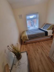 1 dormitorio con cama, ventana y espejo en Somers Lodge en Leicester