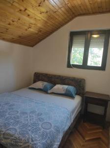 een slaapkamer met een bed met 2 kussens en een raam bij Urban Retreat Zagoric in Podgorica