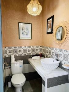 uma casa de banho com um WC branco e um lavatório. em Chez abdelilah em Oualidia