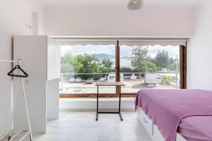 a bedroom with a purple bed and a large window at Seafront Rooms Bitez in Bodrum City