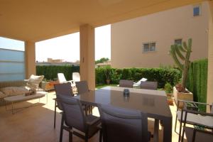eine Terrasse mit einem Tisch, Stühlen und einem Sofa in der Unterkunft Golden in Jávea