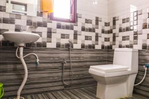 a bathroom with a toilet and a sink at RK GUEST HOUSE in Guwahati +20 photos