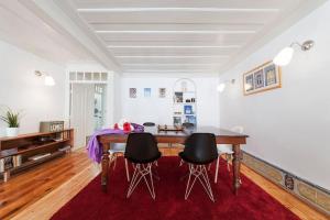 a dining room with a wooden table and black chairs at CHARMING 2 BEDROOM APARTMENT AVENIDA DA LIBERDADE in Lisbon