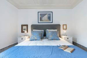 um quarto com uma cama azul com um par de sapatos em CHARMING 2 BEDROOM APARTMENT AVENIDA DA LIBERDADE em Lisboa