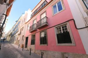 um edifício vermelho e branco numa rua da cidade em CHARMING 2 BEDROOM APARTMENT AVENIDA DA LIBERDADE em Lisboa